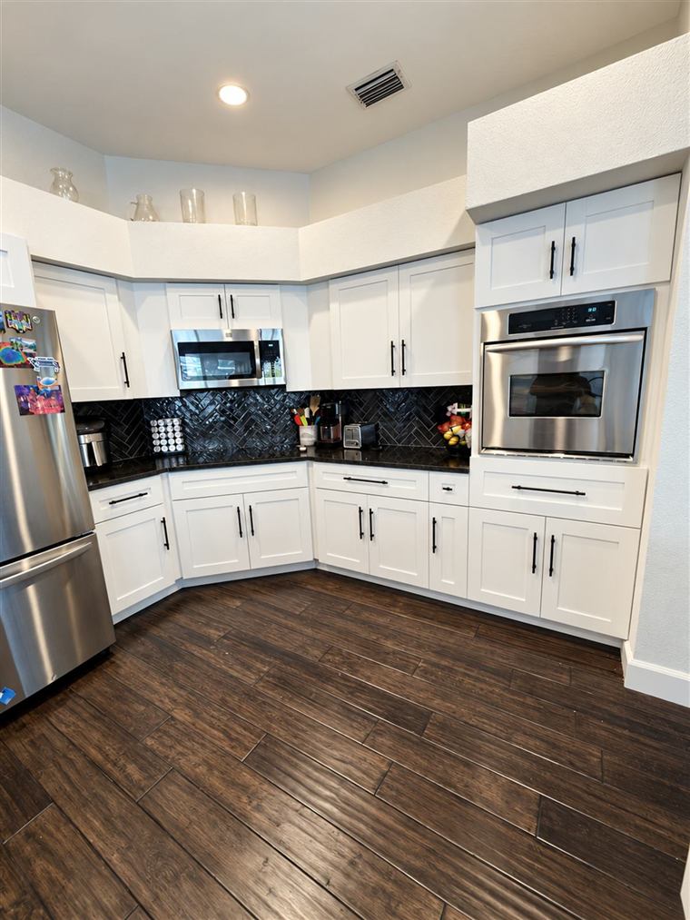 Remodeled kitchen with white cabinets and dark countertops in Clearwater, FL